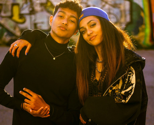 Teen boy and girl standing together hugging