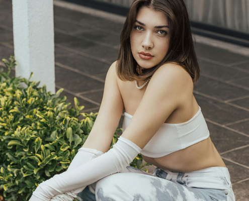 Pretty teen girl kneeling outside