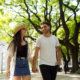 young man and women walking in park holding hands